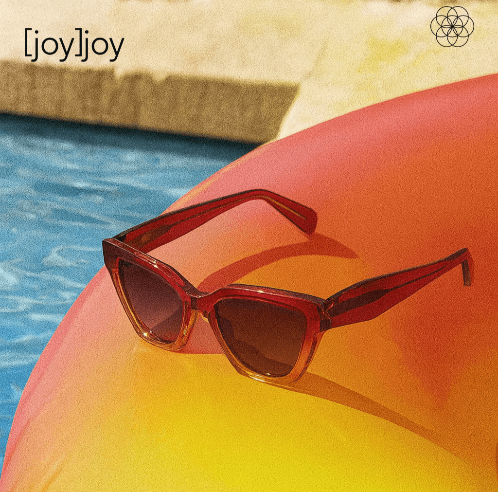 Red sunglasses on a yellow inflatable pool toy with a pool and stone wall in the background, featuring the brand '[joy]joy'.